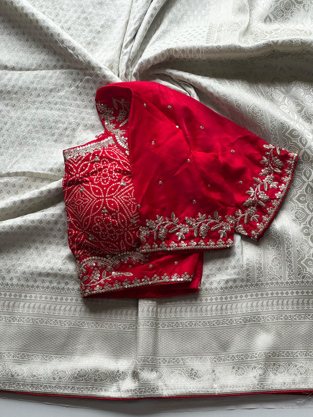 Banarasi Silk White Sari Teamed With Red Bandhej Stiched Blouse