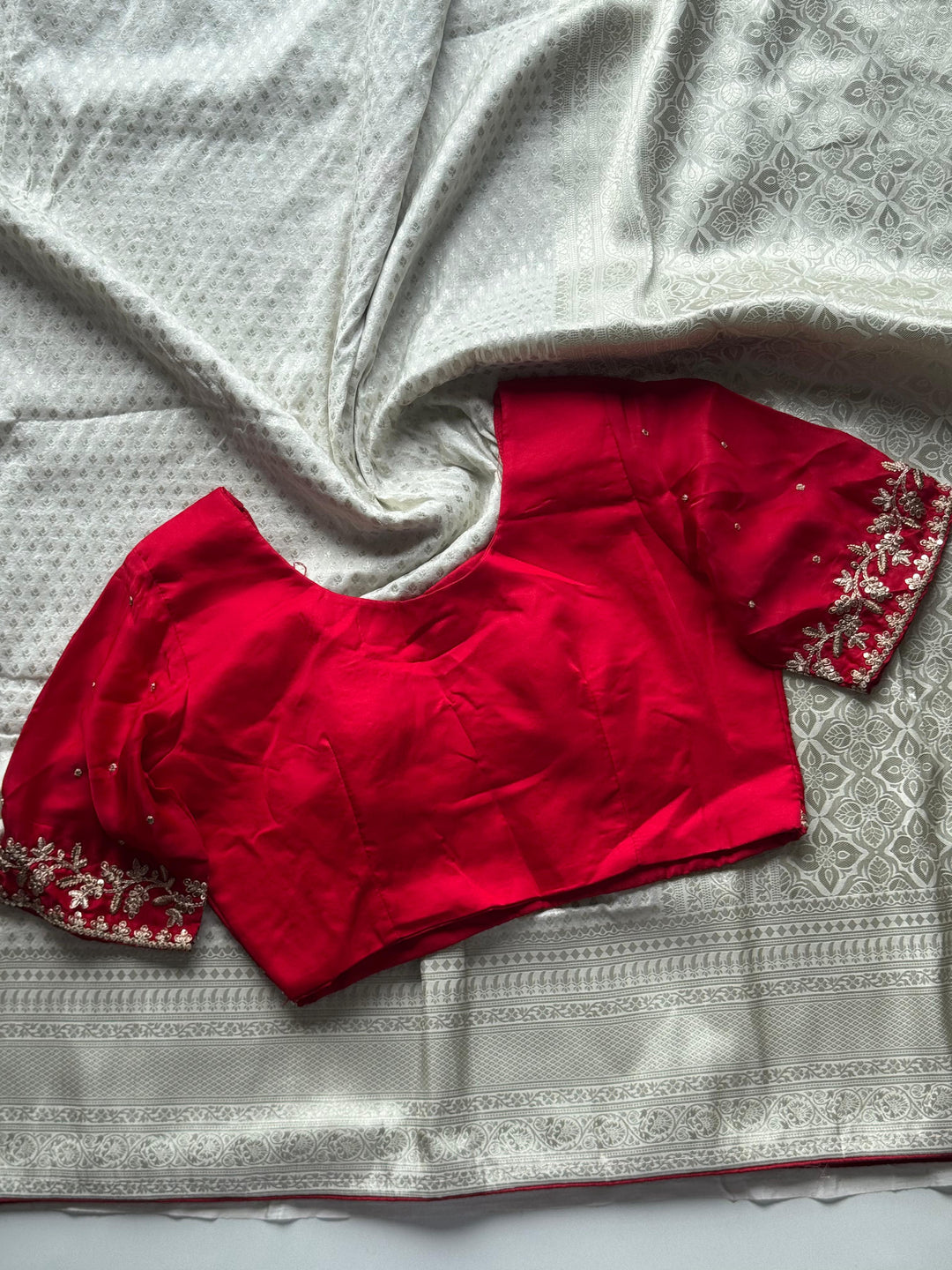 Banarasi Silk White Sari Teamed With Red Bandhej Stiched Blouse